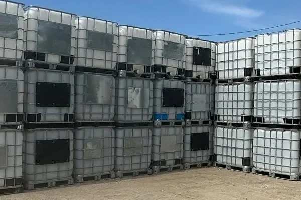 Yard stacked with caged IBC totes ready for reconditioning